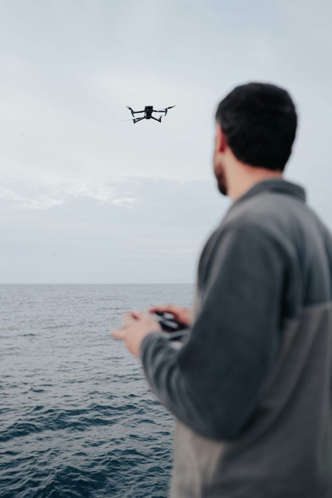 a man standing on a boat looking at a flying object